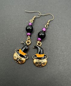 Embrace the spooky season with these Cat Halloween dangling earrings that capture the essence of the holiday perfectly. The lightweight yet eye-catching design ensures comfort while making a bold statement. Whether you're dressing up for a costume party or simply adding a touch of Halloween spirit to your ensemble, these earrings are the ideal accessory. Let these festive earrings be your playful companion throughout the Halloween season, adding a touch of macabre charm to any outfit. Celebrate Spooky Halloween Jewelry For Costume Party, Witchy Halloween Earrings, Spooky Halloween Costume Party Jewelry, Witchy Metal Earrings For Halloween, Witchy Metal Halloween Earrings, Novelty Jewelry For Halloween Costume, Novelty Halloween Costume Jewelry, Spooky Pierced Earrings For Halloween, Witchy Pierced Jewelry For Halloween