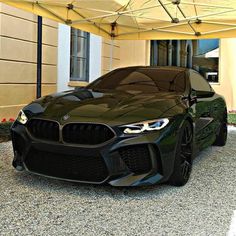 a black bmw sports car parked in front of a building with an awning over it