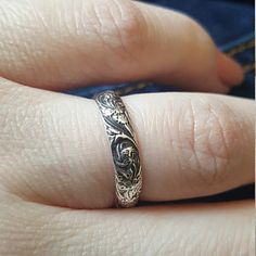 a close up of a person's hand with a wedding ring on their finger