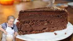 a woman standing in front of a large piece of cake