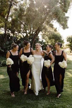 a group of women standing next to each other on top of a lush green field