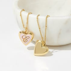 Express your love with the Isla Heart Enamel Locket. This beautiful heart-shaped locket is crafted with soft pink enamel and adorned with a decorative sheen of gold. It's the perfect romantic gift for your special someone. Available in 14k gold plated brass Pendant size: 5/8"x3/4" 16" satellite chain with 2" extender Lobster claw closure Water resistant and protective anti-tarnish barrier With engraving this item is FINAL SALE SKU: BYN1412 Gold Heart Charm Locket Necklace, 14k Gold Heart Locket Necklace Keepsake, Gold Plated Heart Locket Necklace, Heart-shaped Gold Locket Necklace, Gold Brass Heart Pendant Locket Necklace, Enamel Locket, Jewelry Photography Styling, Modern Jewellery Design, Preppy Jewelry