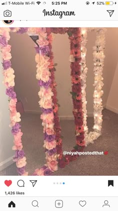 a mirror with flowers on it sitting in the middle of a carpeted floor next to a wall