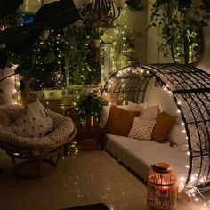 a living room filled with lots of furniture and lights on the walls, along with potted plants