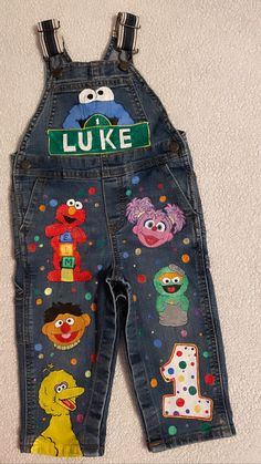 a pair of children's jeans with sesame characters on them