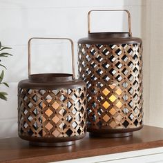 two decorative candle holders sitting on top of a shelf