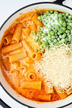 pasta, peas and cheese are in a pan on the stove top with other ingredients