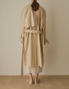 A cool variation of the classic trench, the Lotte Trench features a relaxed, slouchy silhouette with cinchable waist and wrists, rounded shoulders, and deep patch pockets. Also available in dark beige. - Overcut- Pointed collar- Top button closure- Half storm front and back- Removable storm neck piece- Belted waist and cuffs- Angled patch pockets- Back vent- Fully lined- Measurements Length 45.5", Bust 52", Sleeve 31.5"- Outer: 100% Cotton, Lining: 100% Polyester- Dry clean- Imported Beige Belted Outerwear For Daywear, Oversized Beige Outerwear With Belted Cuffs, Oversized Belted Beige Outerwear, Oversized Beige Belted Outerwear, Trench Lighter, Rounded Shoulders, Neck Piece, Dark Beige, Collar Top