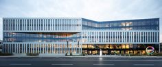 an office building with many windows on the front and side of it's facade