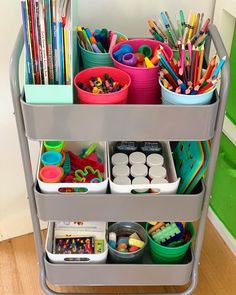 a metal cart filled with lots of different colored pencils and other arts and crafts supplies