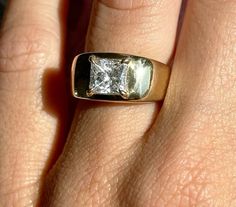 a woman's hand with a ring on it that has a diamond in the middle