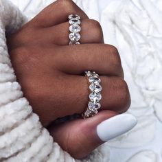 a woman's hand with two rings on her fingers and one ring in the middle