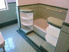 a bathroom with green tile and white fixtures, including a bathtub in the corner