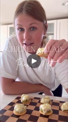 a woman is eating some food on a checkerboard board and looking at the camera