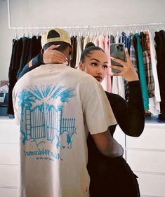 a man and woman standing in front of a closet