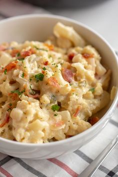 a bowl filled with macaroni and cheese on top of a checkered table cloth