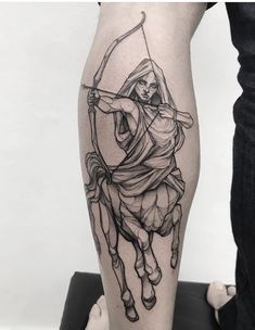 a man with a bow and arrow tattoo on his leg