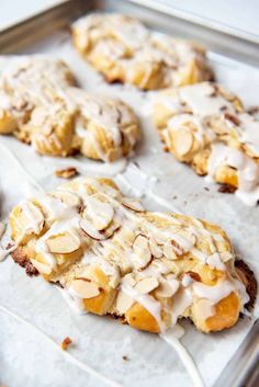 some cookies with icing and almonds on a baking sheet