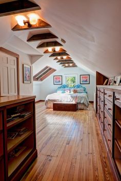 an attic bedroom with wooden floors and white walls