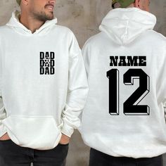 "Personalized Soccer Dad Sweatshirt, Custom Soccer Papa Sweater, Cheer Dad Shirt, Game Day Shirt, Sports Dad Hoodie, Custom Name Shirt This is Moko Shirt!   -Don't forget to see all the photos in listings for details like print color options and sizes and shirt colors.  -Use the drop-down menus to notify the sizes and colors of your shirts.  -Prices vary depend on the shirt sizes.  -Shirts are soft and regular relax fit. Below there are some information about my products and shop.  -Sweatshirt M Sports White Hoodie With Letter Print, Sporty Crew Neck Hoodie With Lettering, Casual Hoodie With Name Print, White Long Sleeve Hoodie With Team Name, White Crew Neck Hoodie With Letter Print, White Cotton Hoodie With Team Name, White Cotton Team Hoodie, White Letter Print Sportswear Hoodie, White Letter Print Hoodie Sportswear