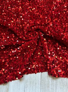 red sequin fabric on white wood floor