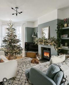 a living room filled with furniture and a christmas tree in the corner next to a fire place