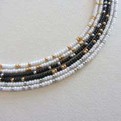 White and gold seed bead choker necklace, Black and silver Boho beaded choker, Long necklaces for women There are 6 necklace options:  1.White natural & gold beads 2.White shiny & gold beads 3.Black & silver beads 4.Black & gold beads 5.White natural & silver beads 6.White shiny & silver beads Clasp options: stainless steel lobster clasp and extension chain, lobster clasp and extension chain are made of brass with 14k gold plating, so the necklace will not lose its look over time! Measure the length of your neck with a measuring tape or you can use any string, rope or phone cable, and afterward apply the measurements on a regular ruler. Choker is 13 inches long with an adjustable extension chain that is 2 inches long. The full length is 15 inches. The necklace is made using size 10/0 Czech Dainty Silver Beaded Choker, Silver Spacer Beads Choker For Gift, White Multi-strand Jewelry With Silver Beads, Minimalist Silver Beaded Choker, Silver Beaded Choker Necklaces With Tiny Beads, White Multi-strand Jewelry With Tiny Beads, Silver Choker With Colorful Round Beads, Silver Beaded Choker With Spacer Beads, Silver Beaded Choker Necklace With Spacer Beads