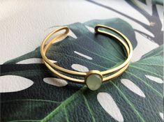 A piece of stylish & modern look gold bangle, which is made with genuine 100% natural real light green Chinese jade bead and 14k gold plated 925 sterling silver bracelet. A great combination of charm and elegance. The minimalistic design is great for your daily wear or special occasions. Perfect as a gift for your loved ones or just as a treat yourself :) Some Highlights of this gold jade bead cuff are: ＊High-quality Material Only 100% natural green jades paired with solid 925 sterling silve Modern Yellow Gold Jade Jewelry, Minimalist Gold Jade Jewelry, Modern Green Bangle Jewelry, Modern Gold Jade Jewelry, Elegant Adjustable Jade Jewelry, Modern Jade Gemstone Jewelry, Gold Jade Bangle Bracelet, Modern Gold Bangle With Gemstone, Modern Green Bangle