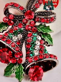 a red and green christmas bell brooch