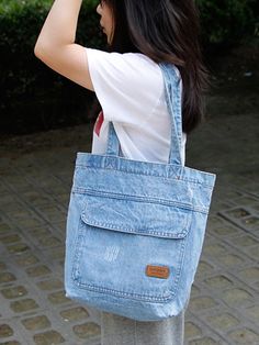 a woman carrying a blue tote bag on her shoulder