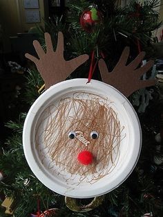 a paper plate reindeer ornament hanging from a christmas tree