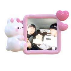 two people sitting in a car with a hello kitty photo frame