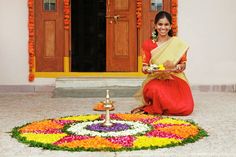 a woman sitting on the ground holding a plate in front of a decorated flower arrangement