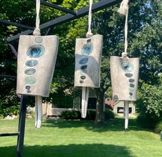 two bird feeders hanging from a metal pole