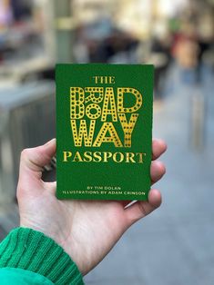 a person holding up a green passport with the words, the road way passport on it