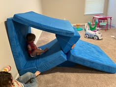 two children playing in a play house made out of blue foams and plastic toys