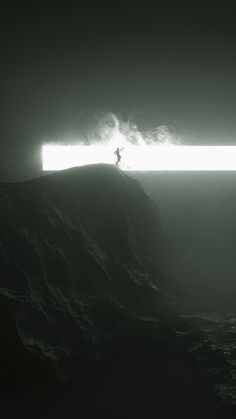 a man standing on top of a large wave in the ocean under a bright light