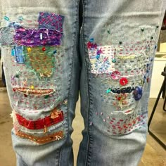 someones jeans are decorated with colorful patches and beads on the bottom part of their pants