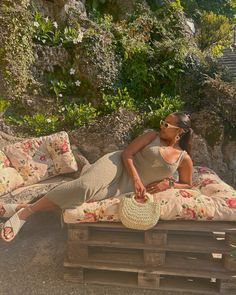 a woman laying on top of a wooden pallet