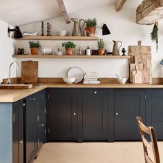 a kitchen with black cabinets and wooden shelves