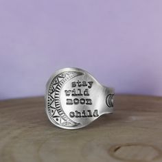 a silver ring with the words, stay dry moon while sitting on top of a wooden table