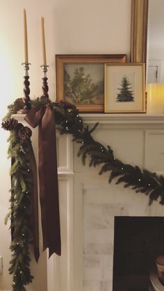 a mantel decorated for christmas with candles and garland