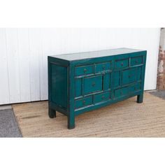 an old dresser is painted teal green