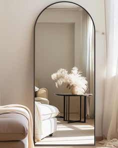 an arched mirror in the corner of a room next to a couch and coffee table