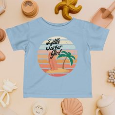 Introducing our adorable Little Surfer Girl T-shirt, the perfect outfit for your little one's beach adventures! Crafted with love and attention to detail, this baby T-shirt combines comfort, style, and a touch of seaside charm. Give your baby a head start on their love for the ocean and beach culture with our adorable Little Surfer Girl T-shirt. Order now and watch your little one ride the waves of cuteness! Key Features: 1. Soft and Gentle Fabric: We understand the importance of keeping your ba Playful Cotton Tops For Summer Adventures, Playful Short Sleeve Tops For Summer Adventures, Blue Cotton Tops For Summer Adventures, Playful Letter Print Top For Beach, Playful Cotton Tops For Beach Season, Playful Letter Print Beach Top, Playful Soft-washed Tops For Summer, Cute Cotton T-shirt For The Beach, Blue Beachy Tops For Summer