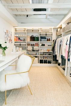 a white chair sitting in front of a closet filled with clothes and other items on shelves