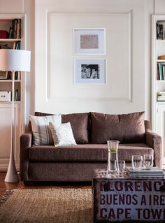 a living room filled with furniture and bookshelves next to a lamp on a table