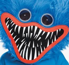 a blue stuffed animal with big eyes and teeth