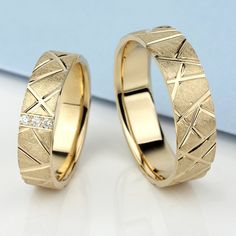 two yellow gold wedding rings with diamonds on the inside and outside, sitting next to each other