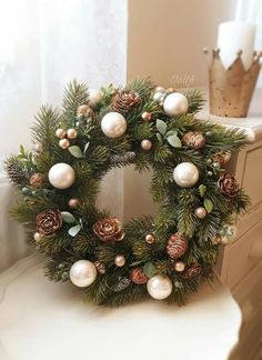 a christmas wreath sitting on top of a white table next to a window sill